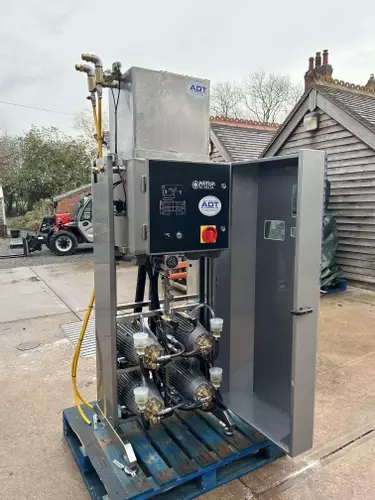 Reconditioned Delta booster pressure washer with cabinet open showing internal pump assemblies before installation at a factory in Measham.